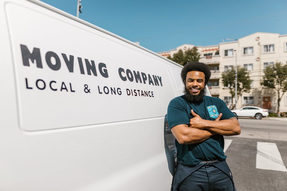 A white Budget moving truck is parked on a paved surface, with the company's logo and website displayed on the side and rear doors. The truck is positioned near an open area, possibly a parking lot or
